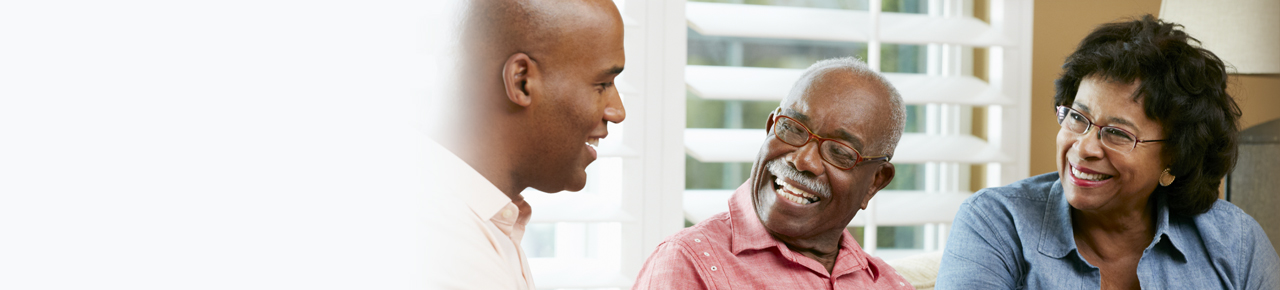 Retired couple wearing glasses smiling at their financial advisor